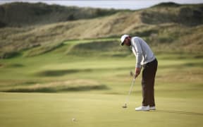 US golfer Scottie Scheffler makes a birdie putt on the 16th green on day two of the 153rd Open Championship at Royal Portrush golf club in Northern Ireland on July 18, 2025. (Photo by HENRY NICHOLLS / AFP) / RESTRICTED TO EDITORIAL USE