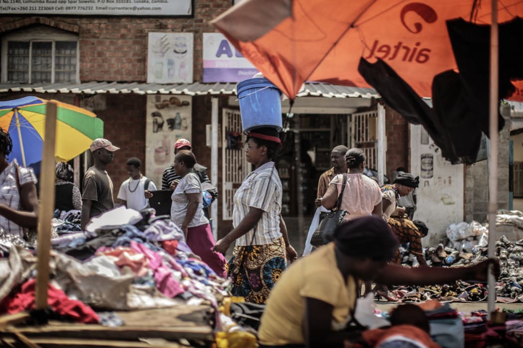 People shop at an open air market on Patrice Lumumba road in Lusaka on November 12, 2014, a day after the burial of the late Zambian president. AFP PHOTO/GIANLUIGI GUERCIA (Photo by GIANLUIGI GUERCIA / AFP)