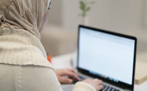 Muslim woman working/writing on laptop/typing.