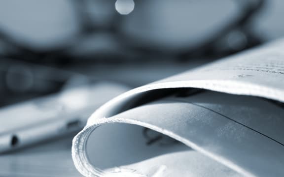 118815655 - a newspaper, reading glasses and a smartphone