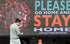 A man walks past a sign on a truck in Melbourne, as the city enforces strict lockdown restrictions.