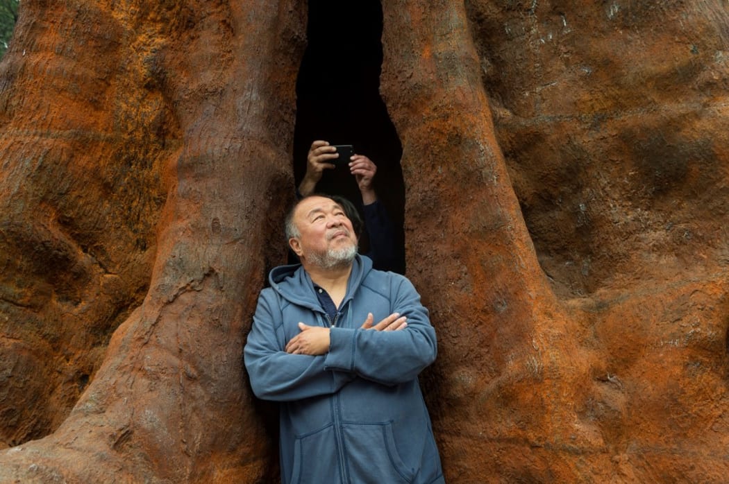 Ai Weiwei poses with his artwork Pequi Tree Portugal 2021.