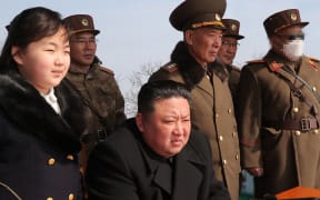 This recent picture released by North Korea's official Korean Central News Agency (KCNA) on March 20, 2023 shows North Korea's leader Kim Jong Un (C) and his daughter (L) observing a warhead missile launch exercise simulating a tactical nuclear attack in Cheolsan county, North Pyongan Province.