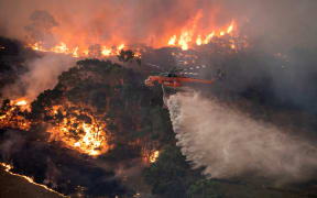 A helicopter fighting a bushfire near Bairnsdale in Victoria's East Gippsland region on 31 December, 2019.