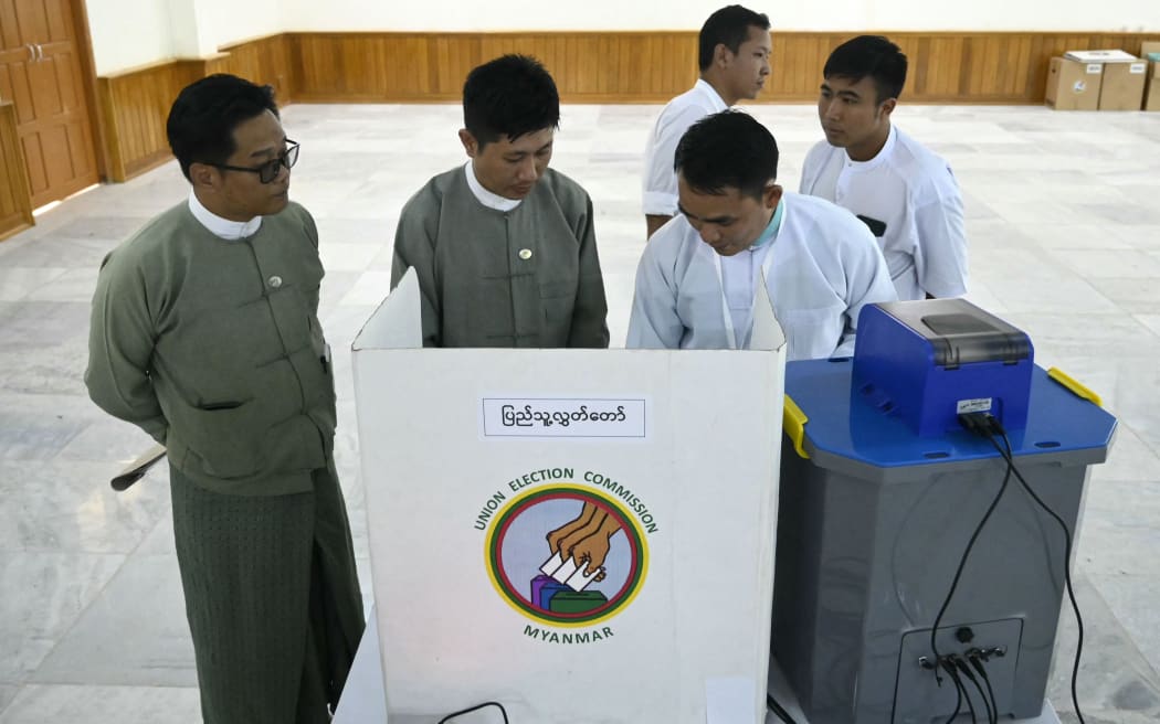 Members of Myanmar's Union Election Commission (UEC) demonstrate a voting machine during the UEC's first major press conference in Naypyidaw on September 11, 2025. Myanmar's ruling junta has said the long-awaited December election would cover about a third of the nation's townships -- despite the conflict raging around the country. The last election in 2020 saw democratic figurehead Aung San Suu Kyi's party win by a landslide before the military ousted her government, making unsubstantiated claims of voter fraud. (Photo by AFP)