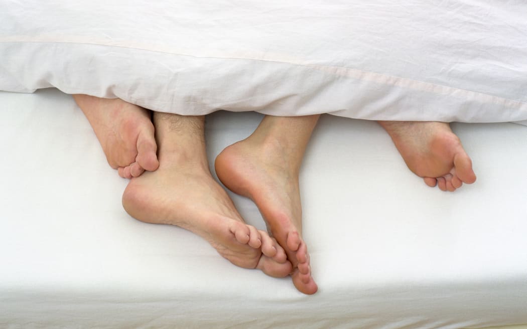 Los pies descalzos de una pareja en la cama (Foto de STOCK4B GMBH / Fuente de la imagen / Fuente de la imagen vía AFP)