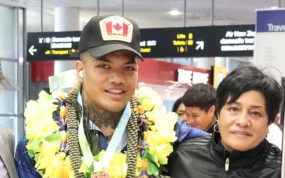 Duken Tutakitoa-Williams and his mother pose at Auckland Airport with medal.