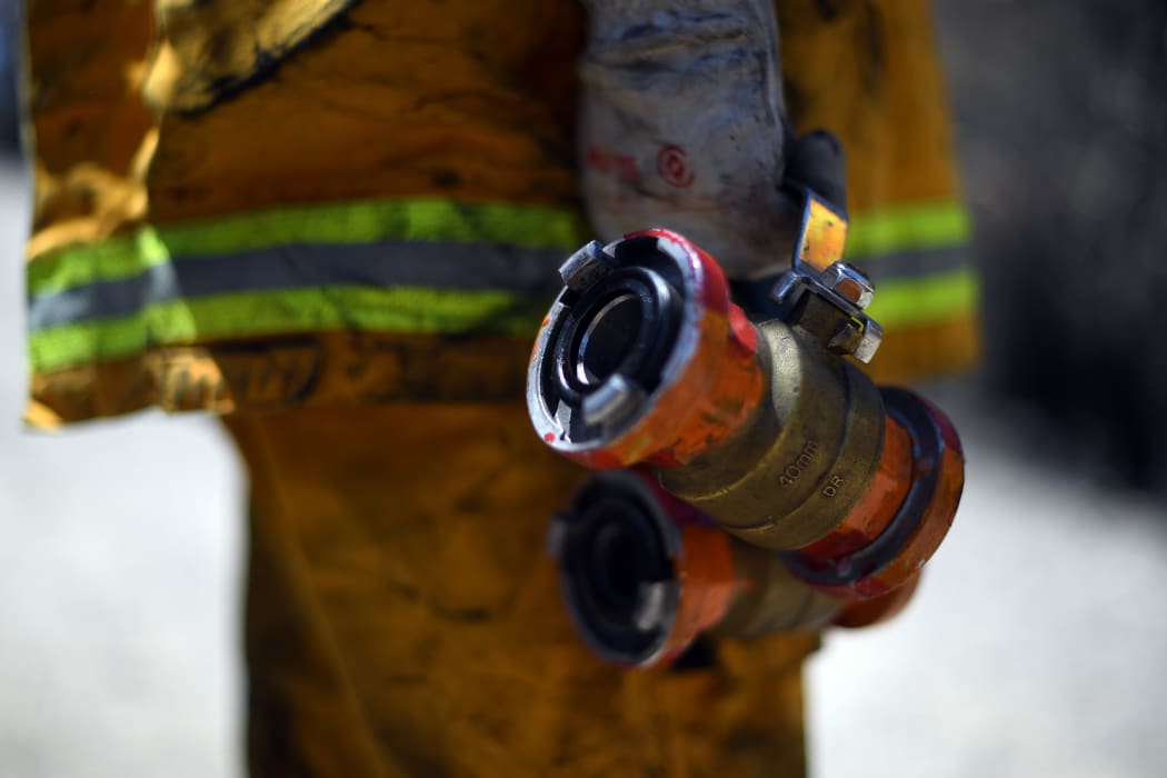 A firefighter proceeds to dose bush fire at the Woodford residential area in Blue Mountains on November 12.