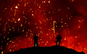 A picture taken on March 16, 2021 shows people watching Klyuchevskoy volcano eruption on Russia's far eastern Kamchatka peninsula. The eruption of a volcano on a Russian peninsula has attracted thrill-seeking tourists risking their lives for picturesque photos, prompting concerns in recent days from local emergency responders. (Photo by MAXIM FESYUNOV / AFP)