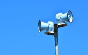 Siren against blue sky for emergency hazard of: tsunami, war, fire and flood.