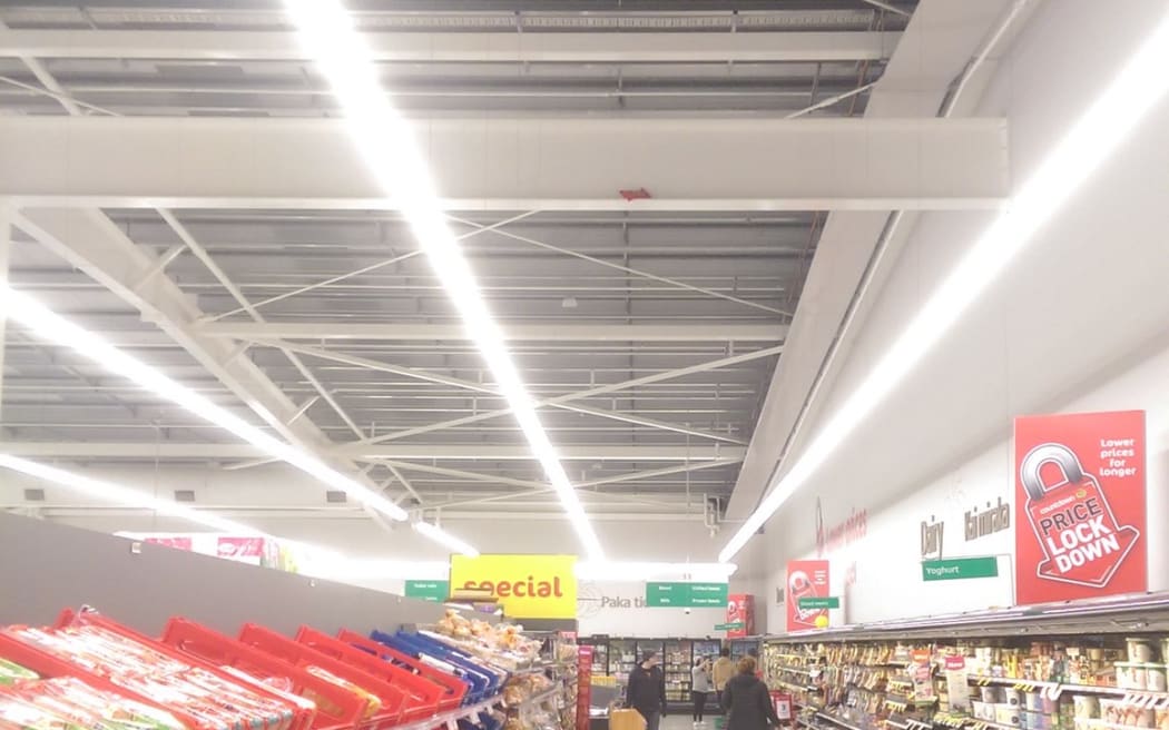 A wide shot of the Dairy aisle in a supermarket, where a packet of corn chips is barely visable on the gerder.