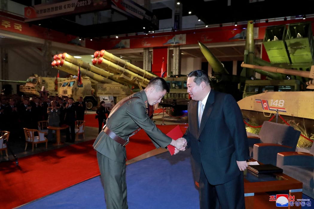North Korean leader Kim Jong Un presenting a commendation award during the defence development exhibition "Self-Defence-2021" at the Three-Revolution Exhibition House in Pyongyang.