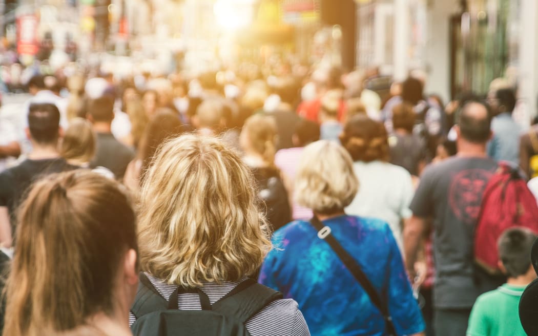Unrecognisable mass of people walking in a city