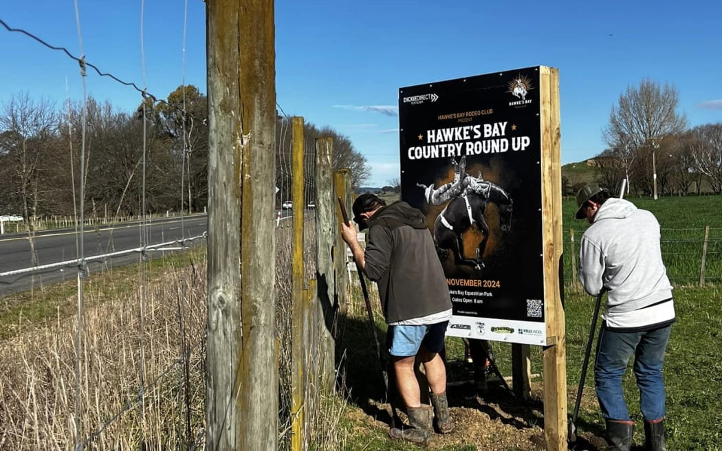 People putting up a sign for the Hawke's Bay Country Round Up rodeo, planned for 30 November, 2024, after 16 years without a local event in the area.