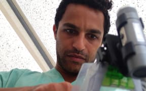 MSF doctor, Dr Javid Abdelmonemin, checks his goggle camera equipment before dressing for his rounds whilst filming for the BBC Panorama documentary 'Ebola Frontline' at MSF