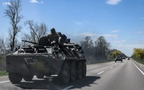 Ukrainian servicemen ride on an armoured personnel carrier (APC) as they make their way along a highway on the outskirts of Kryvyi Rih on April 28, 2022, amid Russia's military invasion launched on Ukraine. (Photo by Ed JONES / AFP)