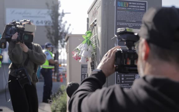 Loafers Lodge resident Chris, last name unknown, lays flowers near the building for his friends he lost in the fire on 16 May, 2023.