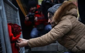 A woman leaves a bouquet of carnation at site to pay tribute to victims of Istanbul night club terror attack in Istanbul, Turkey on January 01, 2017.