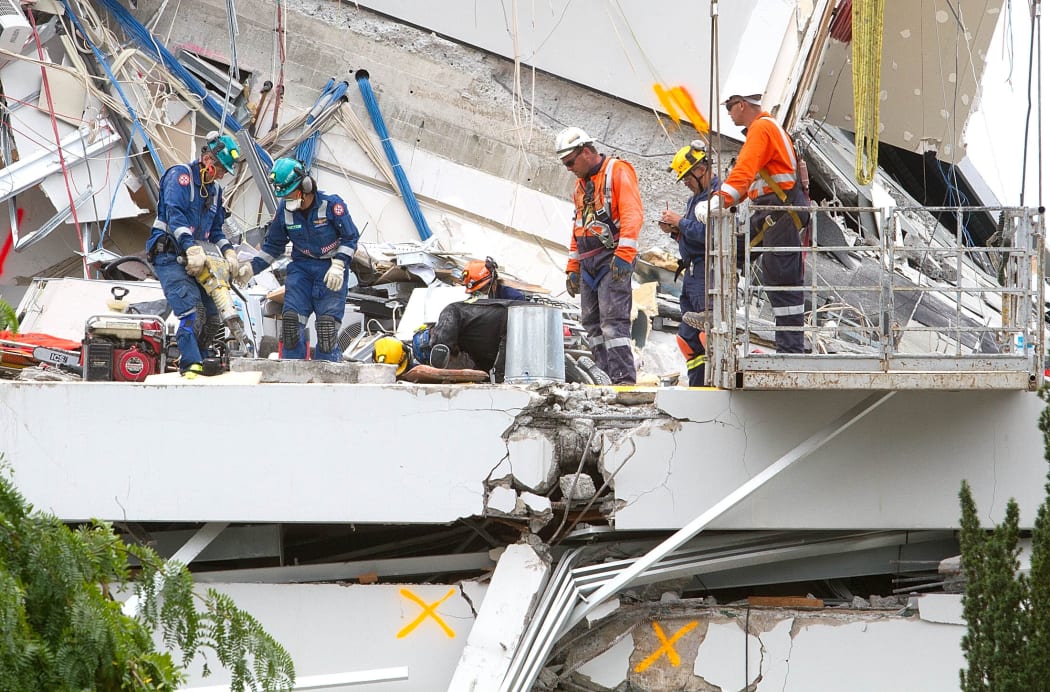 Bill Toomey said the scene that confronted him at the PGC building was horrific. Rescuers trying to find survivors in the building's wreckage on 24 February 2011.