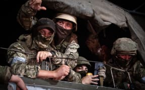 Members of Wagner group looks from a military vehicle in Rostov-on-Don late on June 24, 2023. Rebel mercenary leader Yevgeny Prigozhin who sent his fighters to topple the military leaders in Moscow will leave for Belarus and a criminal case against him will be dropped as part of a deal to avoid "bloodshed," the Kremlin said on June 24. (Photo by Roman ROMOKHOV / AFP)