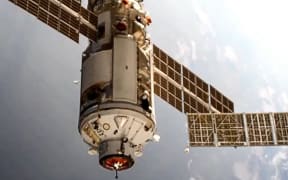 This handout photograph taken and released by the Russian Space Agency Roscosmos on July 29, 2021, shows the Russian Multipurpose Laboratory Module "Nauka" (Science) docking to the International Space Station (ISS).