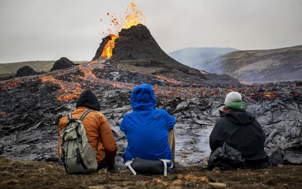 Sunday hikers look at the lava flowing from the erupting Fagradalsfjall volcano some 40 km west of the Icelandic capital Reykjavik.