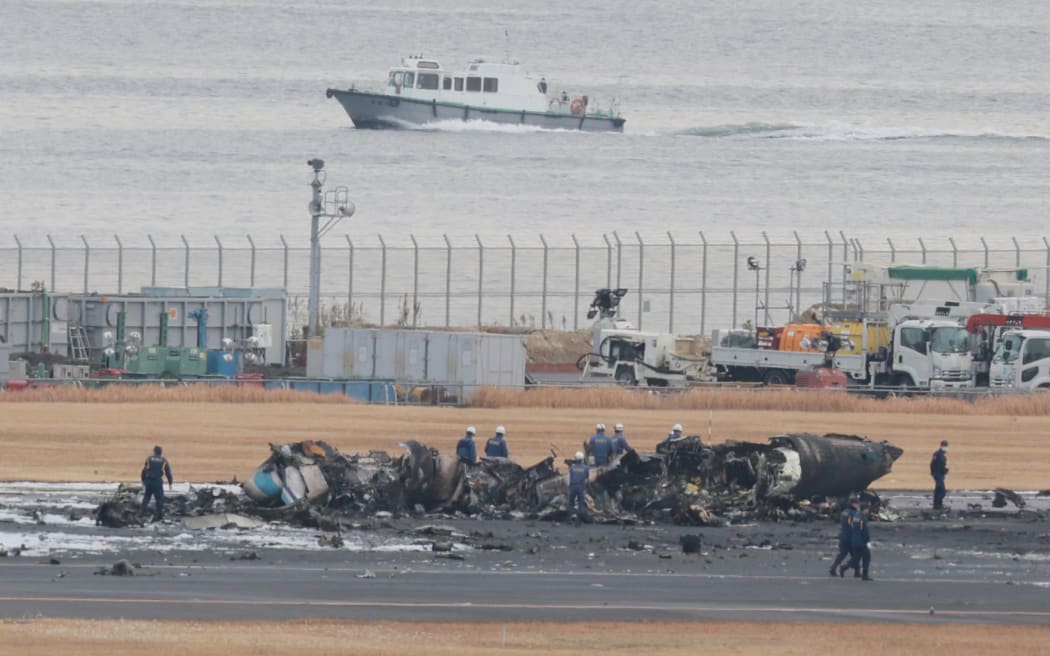 A burnt Japan Airlines plane is pictured on the runway at Haneda Airport in Ota Ward, Tokyo on Jan.3rd, 2024. The JAL passenger aircraft and a Japan Coast Guard aircraft, a Bombardier MA722, collided on the runway on the previous day.  ( The Yomiuri Shimbun ) (Photo by Koki Kataoka / Yomiuri / The Yomiuri Shimbun via AFP)