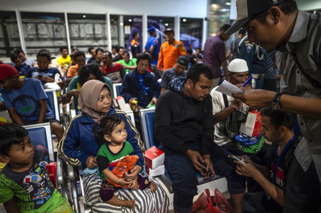 Passengers of a ferry that caught fire gather at Tangjung Perak seaport, after being evacuated, in Surabaya, East Java.