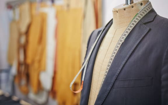 New jacket being sewn on mannequin and a measuring tape.