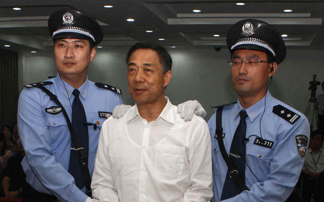This picture taken on September 22, 2013 and released by Jinan Intermediate People's Court shows Chinese political star Bo Xilai (centre) wearing a pair of handcuffs as he stands in a courtroom in Jinan, east China's Shandong province. One of the last images available of Bo Xilai, once a rising star in the Chinese Communist Party