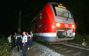 Police officers stand by a regional train in Wuerzburg in southern Germany on July 18, 2016