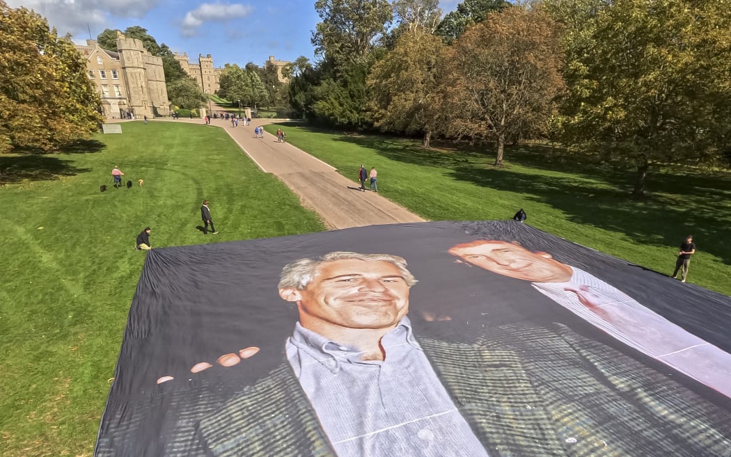 A handout image from the UK collective 'Everyone Hates Elon' shows activists unfurling a large photo depicting US President Donald Trump posing with Jeffrey Epstein, on the Long Walk, outside Windsor Castle.
