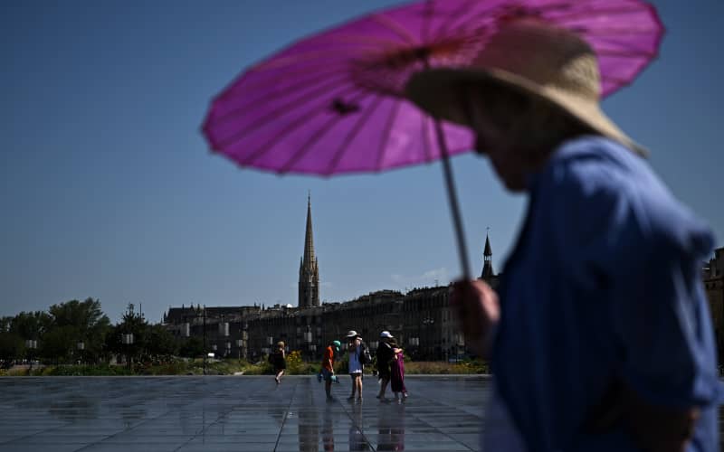 Visitors walk across the Mirroir d’Eau reflecting pool to cool down in Bordeaux, southwestern France on June 23, 2026, as France experiences a heatwave. (Photo by Christophe ARCHAMBAULT / AFP)