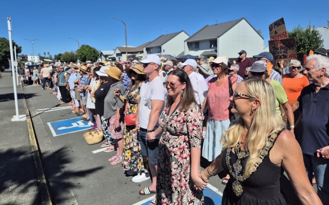 About 250 people formed a human chain outside Napier Health to protest cuts to urgent after-hours services.