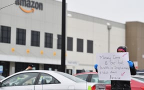 In this file photo taken on March 30, 2020 Amazon workers at Amazon's Staten Island warehouse strike in demand that the facility be shut down and cleaned after one staffer tested positive for the coronavirus in New York.