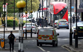 Police officers work outside the Houses of Parliament following an incident where a car crashed into barriers.