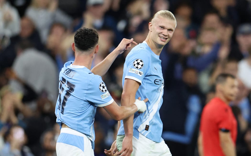 Manchester City's Erling Haaland, right, celebrates with teammate Phil Foden after scoring against Napoli in their Champions League match in Manchester, September 18, 2025. (Photo by Darren Staples / AFP)