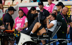 Kalpo Olsen-Baker of New Zealand leaves the pitch with a badly injured leg.