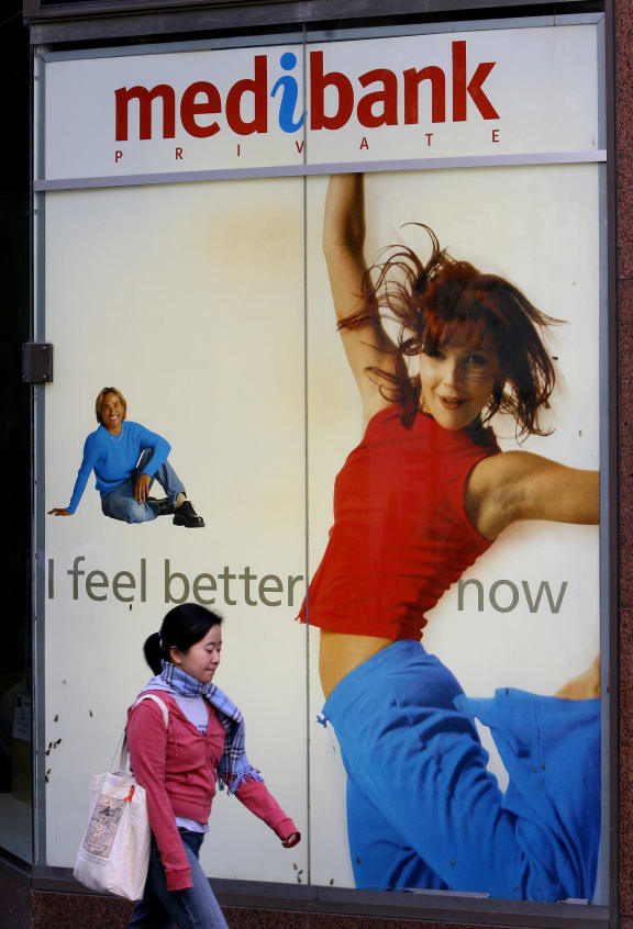 A woman walks past a Medibank Private office in Sydney.
