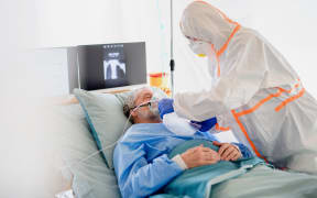 An infected patient in quarantine lying in bed in hospital.