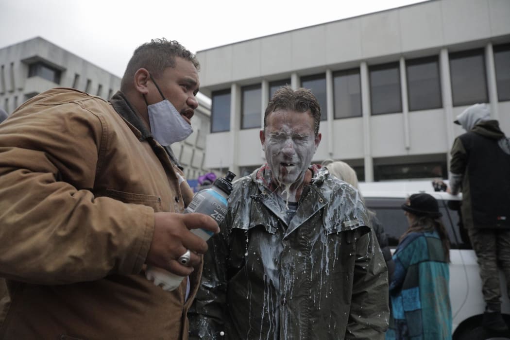 A protester seen with milk on their face - something used to cool the effects of pepper spray.