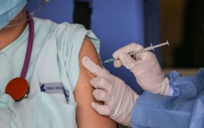 A healthcare worker injects a dose of the Pfizer-BioNTech Covid-19 vaccine to an emergency doctor in Colombia on February 18, 2021.