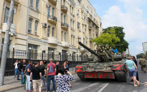 Members of Wagner group sit atop of a tank in a street in the city of Rostov-on-Don, on June 24, 2023. President Vladimir Putin on June 24, 2023 said an armed mutiny by Wagner mercenaries was a "stab in the back" and that the group's chief Yevgeny Prigozhin had betrayed Russia, as he vowed to punish the dissidents. Prigozhin said his fighters control key military sites in the southern city of Rostov-on-Don. (Photo by STRINGER / AFP)