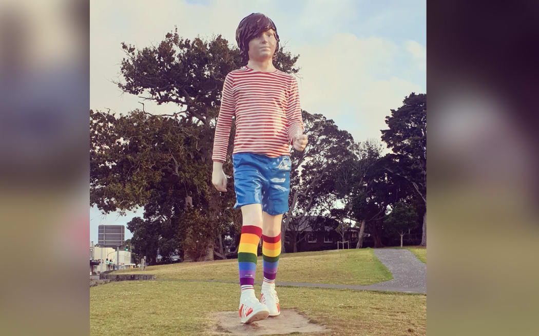 A large statue of a child wearing rainbow socks.