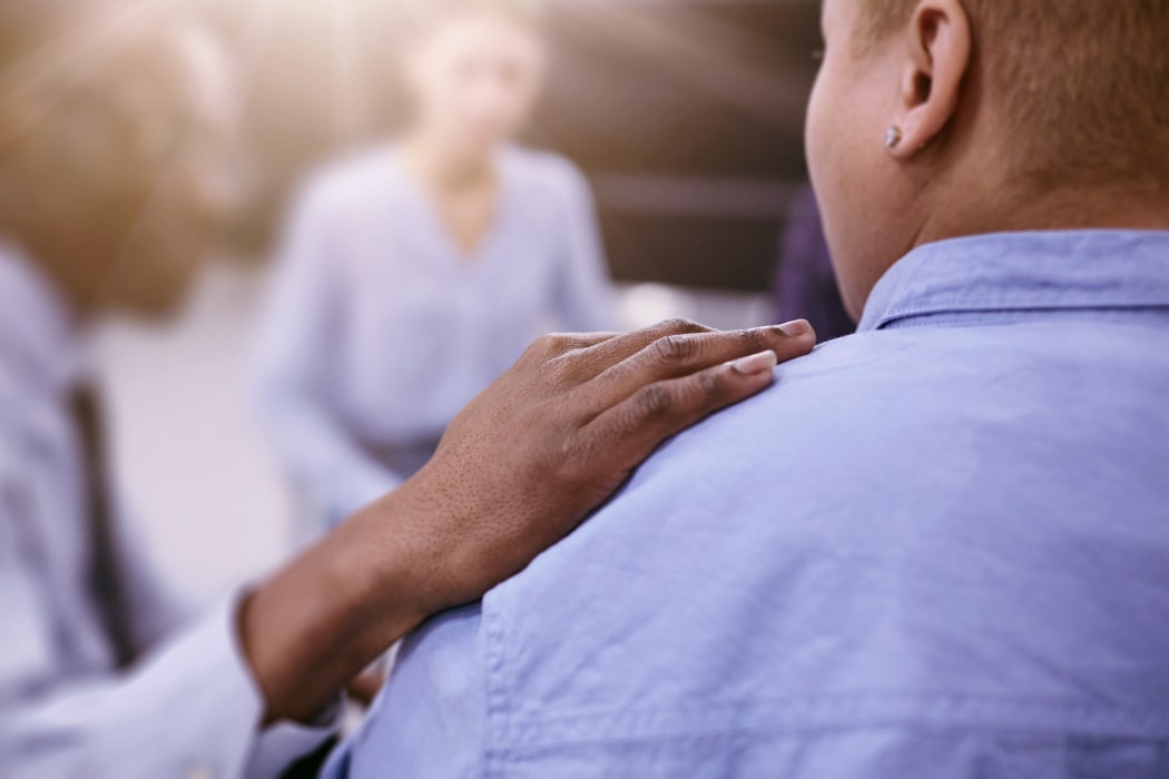 Closeup of unrecognizable African man comforting woman during group therapy session with psychologist, copy space