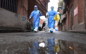 Staff members prepare to conduct nucleic acid test for a citizen discharged from a makeshift hospital in Huangpu District, east China's Shanghai.