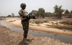 A Nigerian soldier, with a grenade launcher, stands guard near the Yobe river, that separates Nigeria from Niger, on the outskirt of the town of Damasak in North East Nigeria on April, 25 2017.