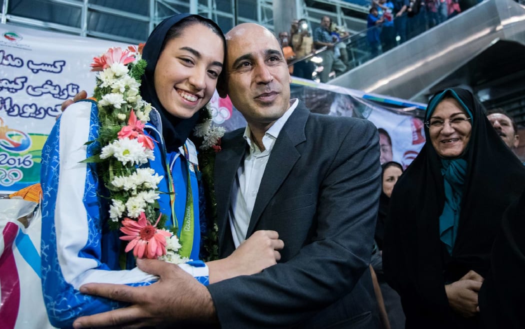 (FILES) In this file photo taken on August 26, 2016 Kimia Alizadeh who became the first Iranian woman ever to win an Olympic medal, is greeted by her father Keivan Alizadeh (R) at Imam Khomeini International Airport in the capital Tehran.