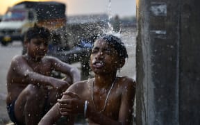 Boys bathe at a public water facility along a street on a hot summer day in Jalandhar on June 13, 2024 amid heatwave. India's heatwave is the longest ever to hit the country, the government's top weather expert said on June 10 as he warned people will face increasingly oppressive temperatures. Parts of northern India have been gripped by a heatwave since mid-May, with temperatures soaring over 45 degrees Celsius (113 degrees Fahrenheit).