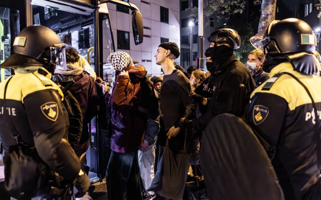 Participants in a pro-Palestinian protest are evacuated by bus under police surveillance at the campus of the University of Amsterdam (UvA) on Roeterseiland.